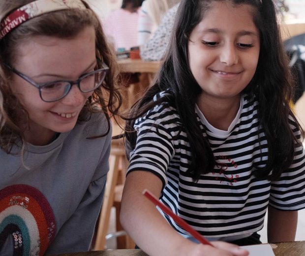 Two children smiling while drawing.