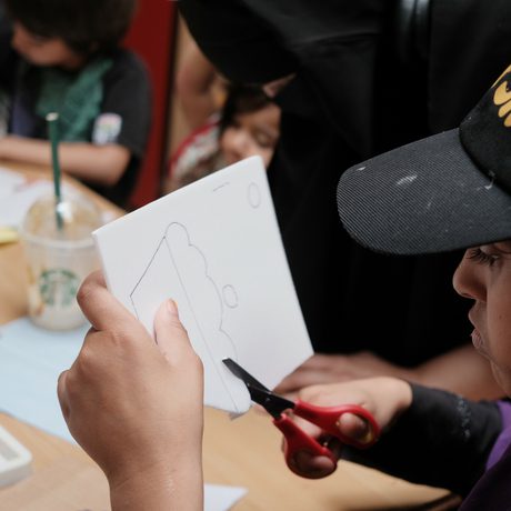 A person cutting a shape out of a piece of paper.