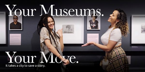 Two smiling people in a gallery with the text that reads 'Your Museums. Your Move.'