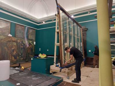 A man is expecting the empty frame that has been removed from the painting.