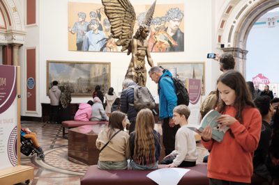Visitors in an art gallery with large sculpture in the centre.