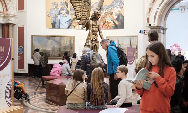 Visitors in an art gallery with large sculpture in the centre.