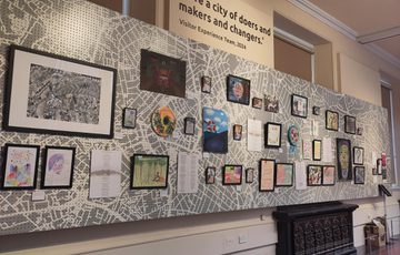 Image shows a full span of the Carers Voices display, showing various self-portraits, poetry, digital artwork and collaged pieces.