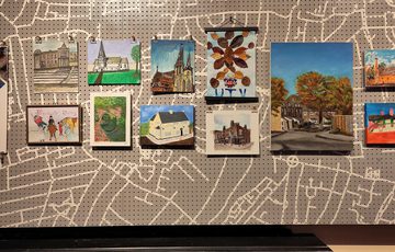 Image shows a cropped section of a community art display depicting streets and houses across Birmingham, where local people live. Includes colourful drawings and paintings of various sizes.