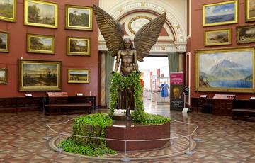 The state of Lucifer is holding green carnations that drape over his hands and onto the floor.