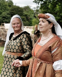 Two ladies dressed in medieval replica costumes.