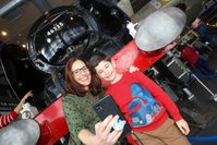 An adult and child taking a selfie in front of the steam train.