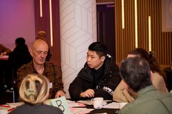 A group of participants sitting around a table having a discussion.