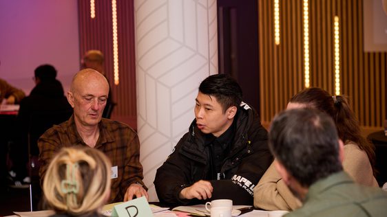 A group of participants sitting around a table having a discussion.