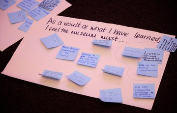 A large paper with blue sticky notes and writing on a table.