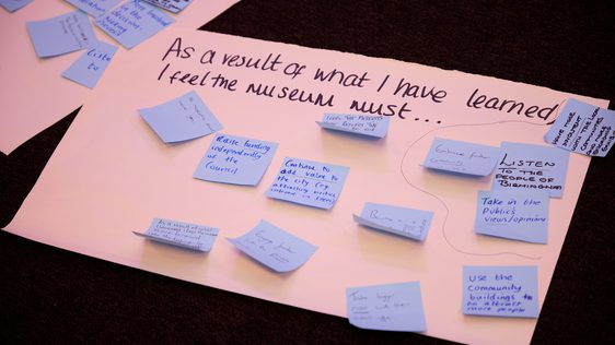 A large paper with blue sticky notes and writing on a table.