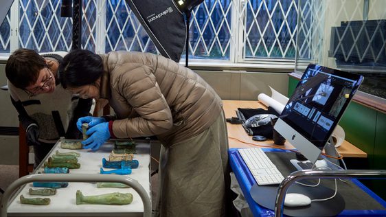 A pair of researchers analysing collections items