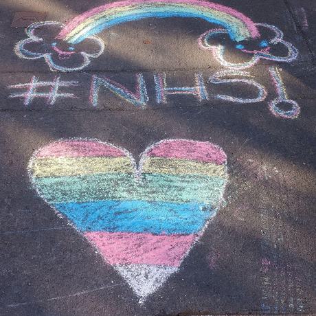 A chack drawing if a heard in rainbow colours, with a rainbow drawn above it and the words NHS.