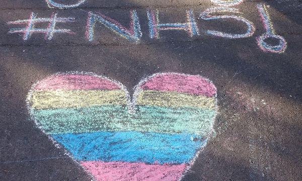 A chack drawing if a heard in rainbow colours, with a rainbow drawn above it and the words NHS.