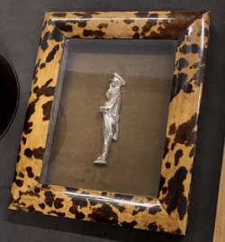 A tortoise shell style frame with profile view of a person in silver.