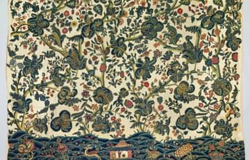 Heavily-embroidered bed cover with patterns taken from nature of plants and animals
