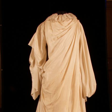 Long, loose, draped dress with long sleeves in a plain light fabric