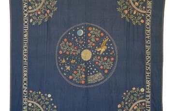 Square embroidered bed cover, with a poetic quote around the edges, a rainbow at each corner, a circle pattern in the middle with a sun at its centre, divided into 8 panels with animals of the day and night and flower and plant motifs