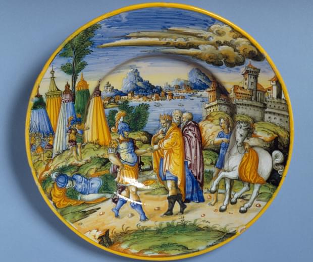Round, ceramic plate with painting depicting a scene from Greek mythology of the Seige of Troy