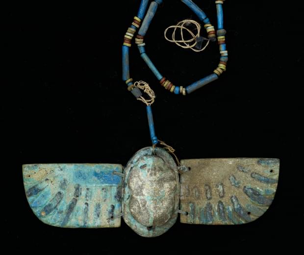 Blue pottery charm in the shape of a beetle with wings, a beaded pottery chain is attached to the top