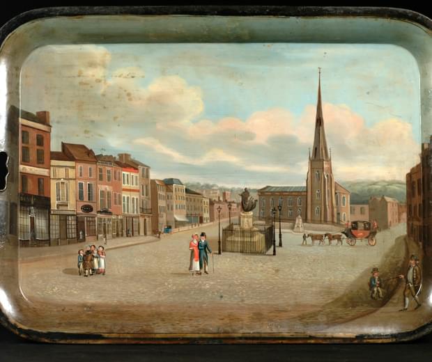 Metal tray painted with a 19th century street scene with a church in the background