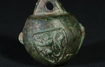 Metal sphere with a heraldic lion in relief, there is a triangular flat part on the top with a hole