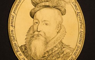 Gold coloured coin with a portrait of a bearded man's bust finely engraved. He wears luxurious clothes and feather in his hat