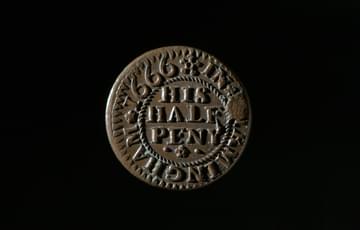Dark coloured coin with 'His Half Peny' in the centre encircled by wording saying 'In Birmingham 1666'