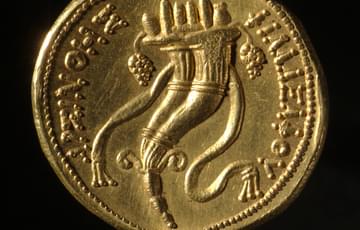 Gold coloured coin with Horn of Plenty circled with Greek writing