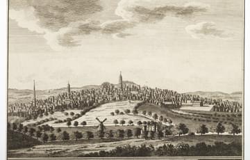 Etching of a panoramic view of a town showing church spires and a windmill