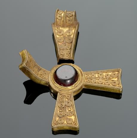 Gold pendant in the shape of a cross with a round garnet stone in the centre and filigree decoration