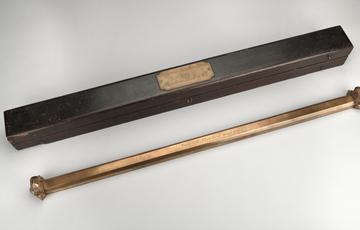 A thick, brass coloured pole with a cluster of spikes at either end