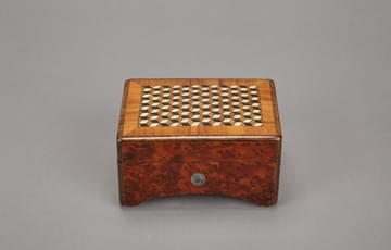 Small, wooden music box with geometric cube pattern on the lid
