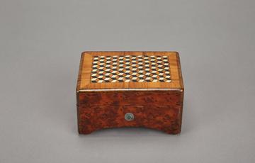 Small, wooden music box with geometric cube pattern on the lid