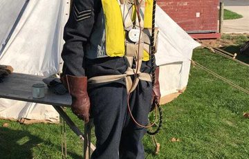 A person dressed in an historic RAF costume with mask covering their face.