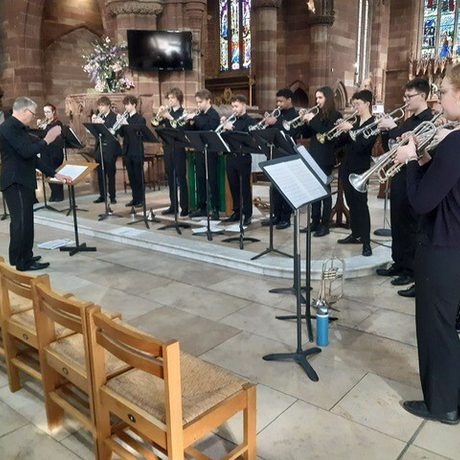 A group of people playing trumpets within a church setting.