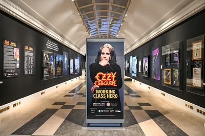 Ozzy Osbourne exhibition with black walls featuring Ozzy Osbourne items and memorabilia.