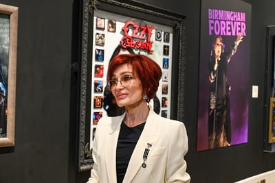 Sharon Osbourne standing in the Working Class Hero exhibition.