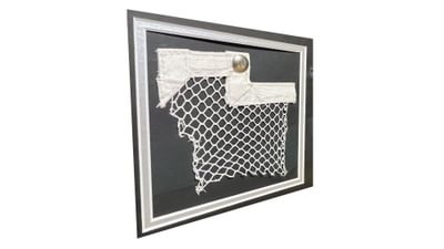 A section of netting on display in a frame.