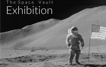 Black and white photo of an astronaut on the moon with USA flag next to him.