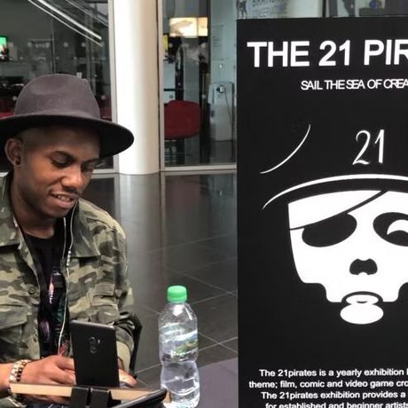 A person seated with a poster next to them.