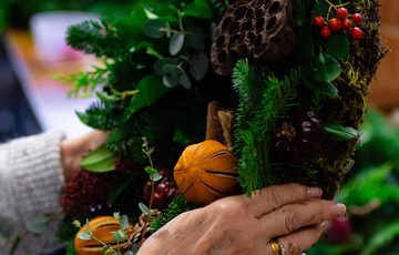 Close up of hands holding a wreath.