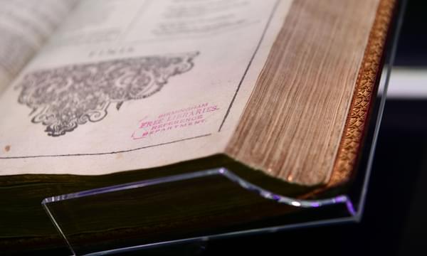 The corner of Shakespeare's First Folio book, showing a page and the leaves of the book.