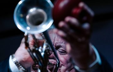 Close up of a person playing a trumpet.