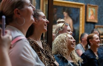 A close up of people laughing in a gallery.