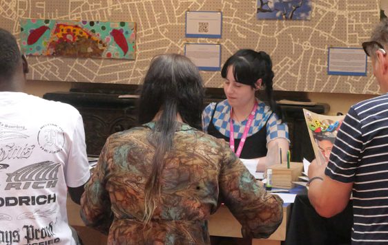 Picture of a group of people sat at a table, with a map background