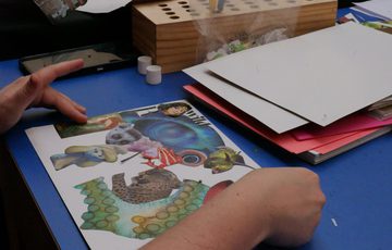 Picture of a collage with colourful drawing of animals on a blue table