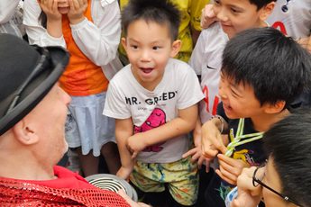 An adult with a group of smiling children.