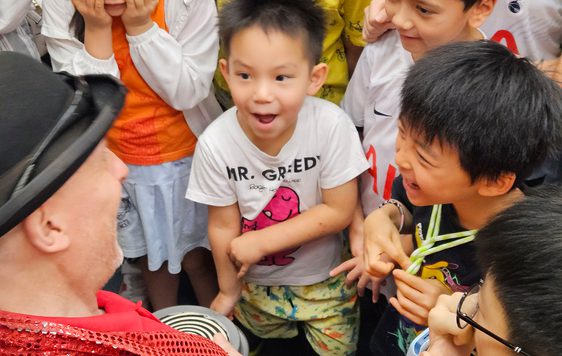 An adult with a group of smiling children.