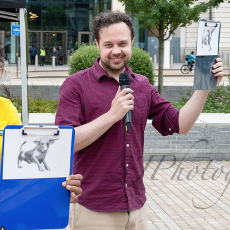 Picture of a man in a purple shirt holding a pencil drawing of a bull. A copy of the bull picture on a blue clipboard to the left of the image